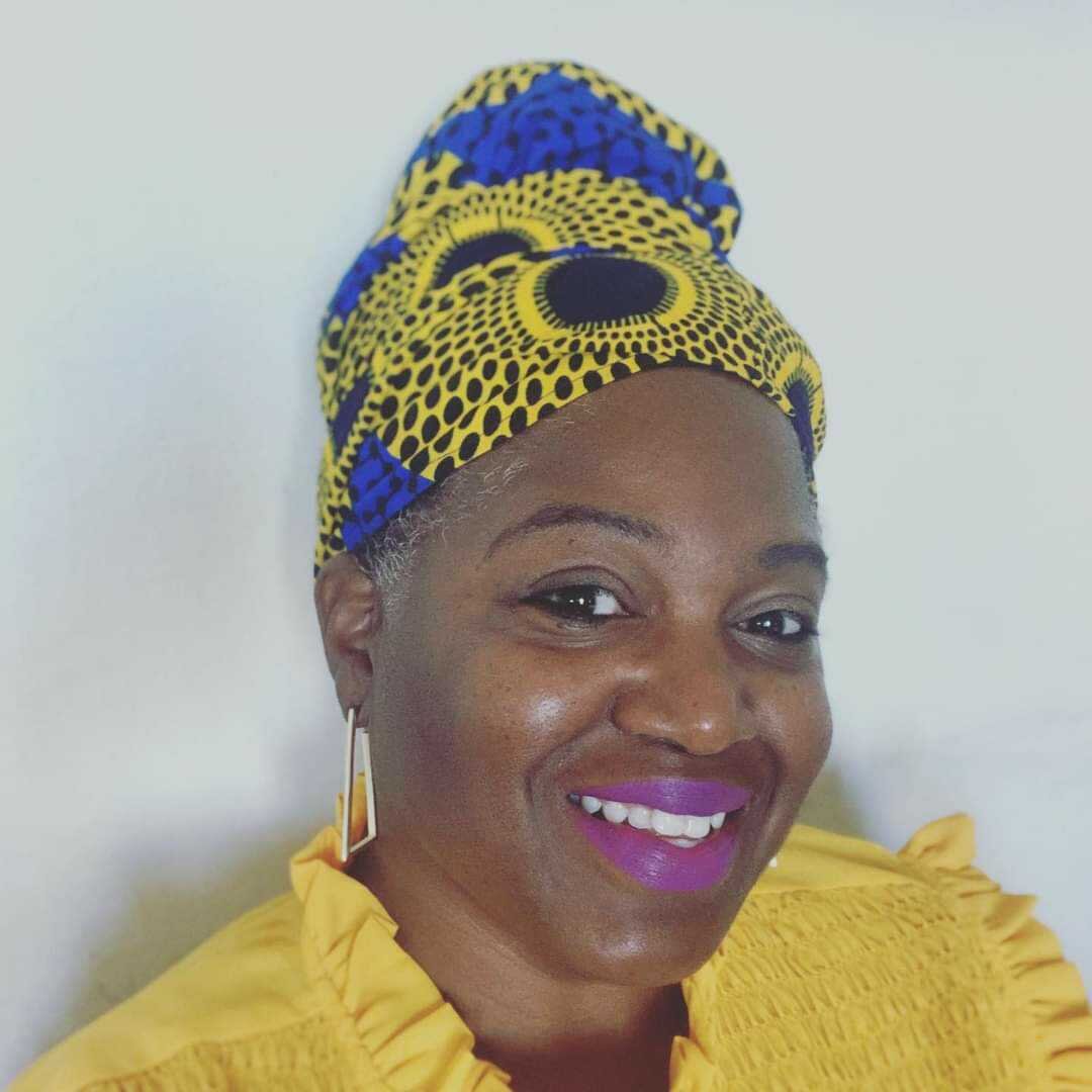 Archette Holmes smiling, wearing her own creations.