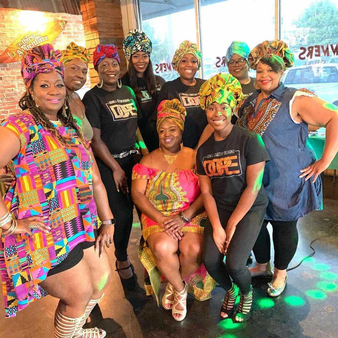 Archette accompanied by a group of models showcasing her designs.